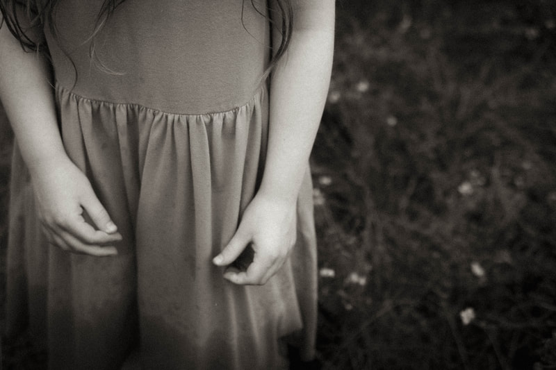 a black and white photograph of a little girls hands, by Two Harbors photographer Kayla Schiltgen
